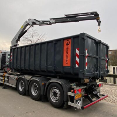 Een grote donkergrijze afzetcontainer op een vrachtwagen